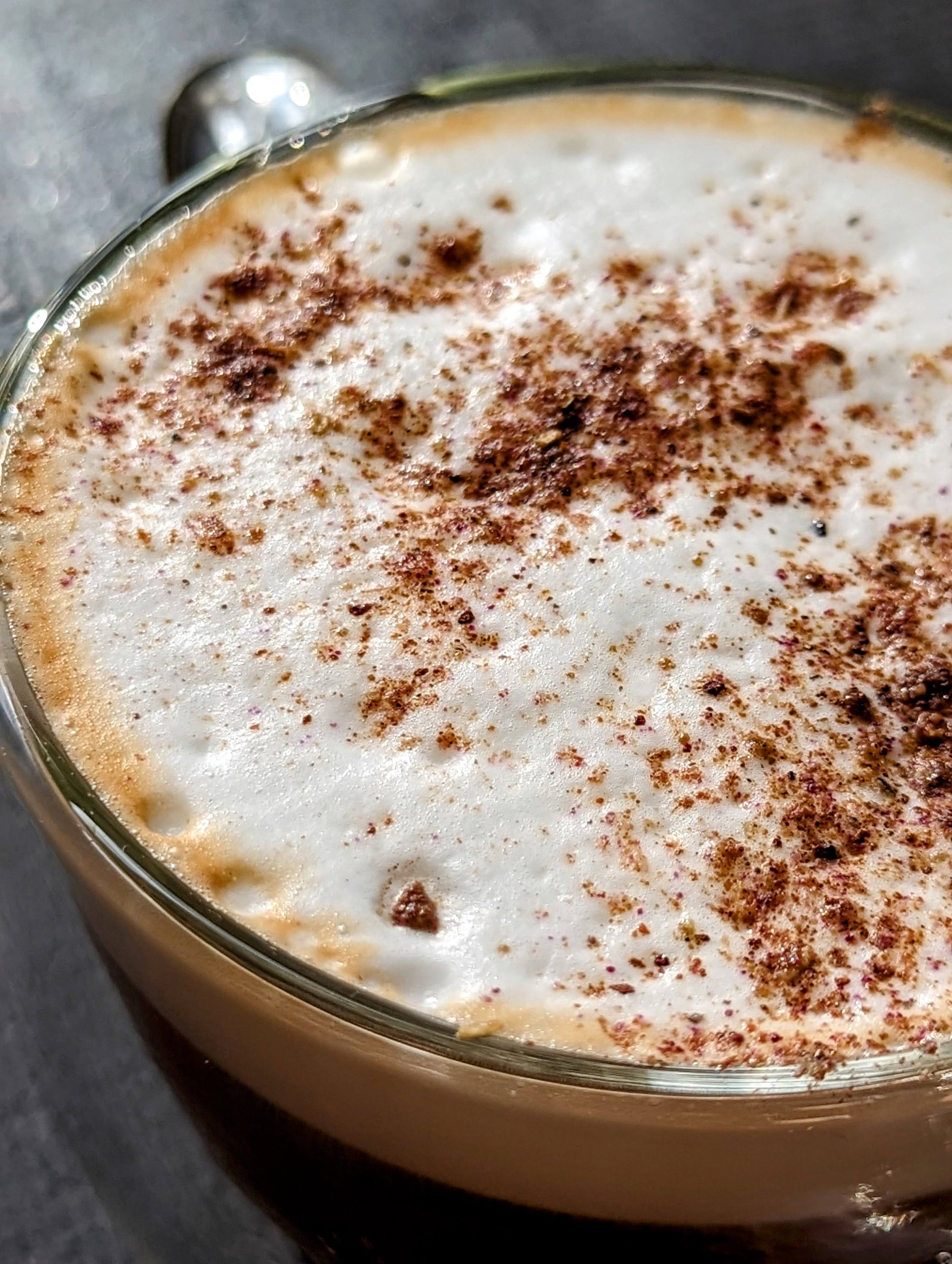 mug with a chai latte, foamy milk, sprinkled with dhol chai spice