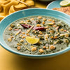 a bowl of spinach curry with chickpeas and spices