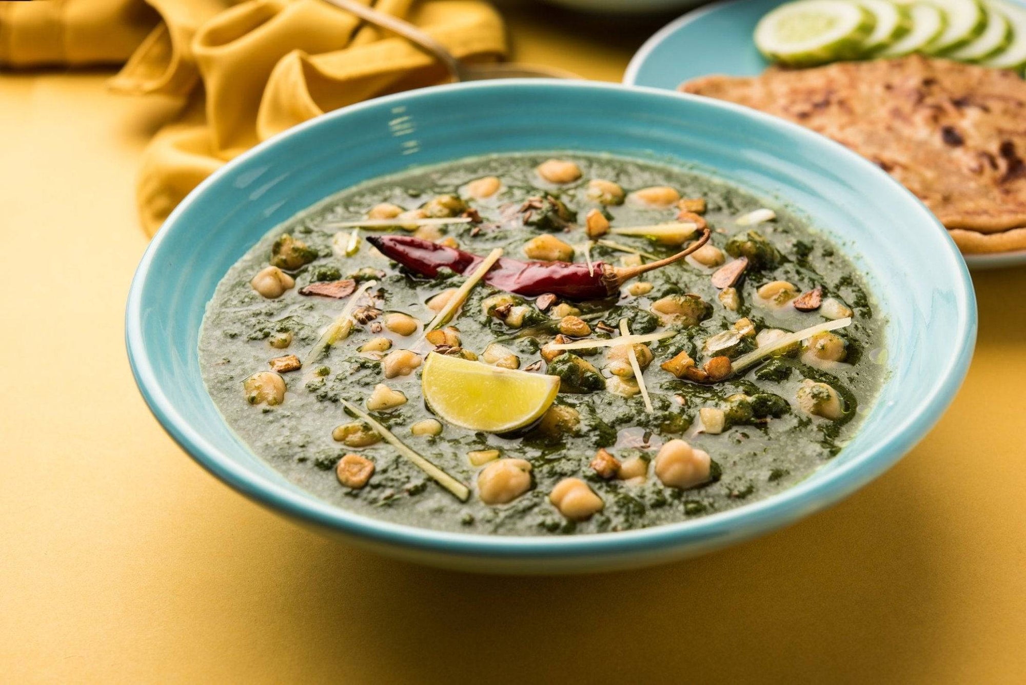 a bowl of spinach curry with chickpeas and spices