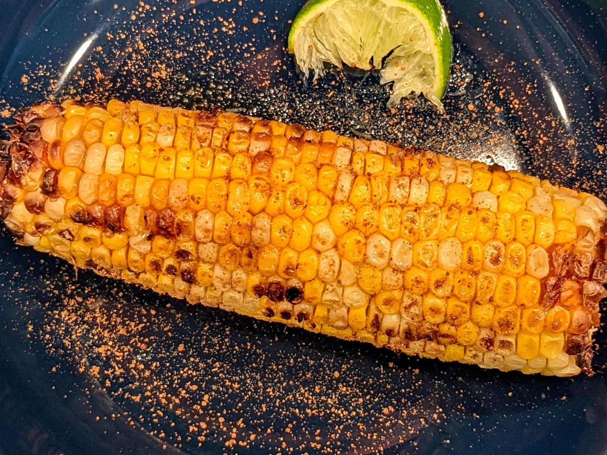 Sprinkle DHOL Popcorn spice on grilled corn for a flavorful summer treat