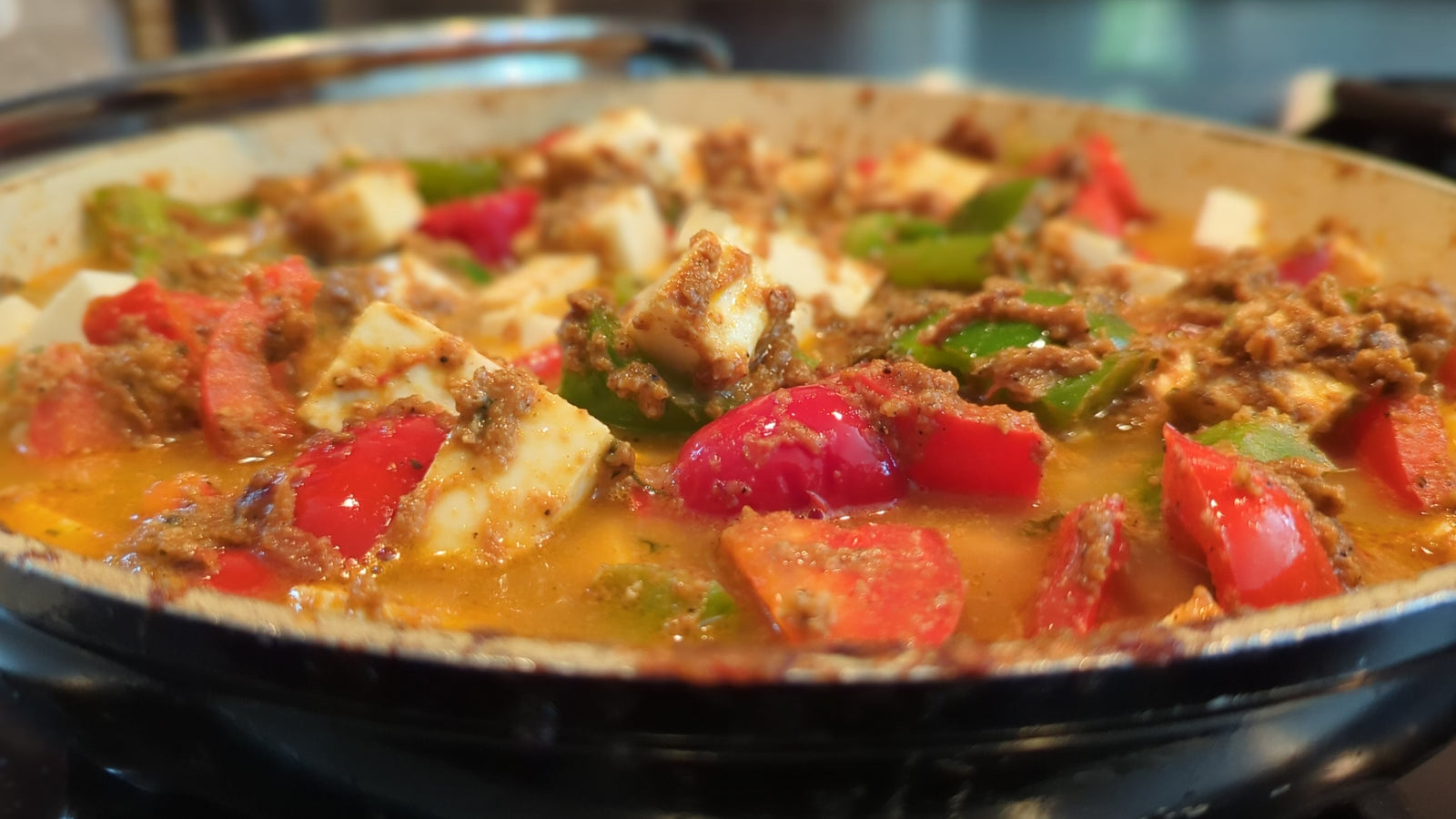 a homestyle cheese with crispy red and green bell peppers in a rich onion and tomato base curry